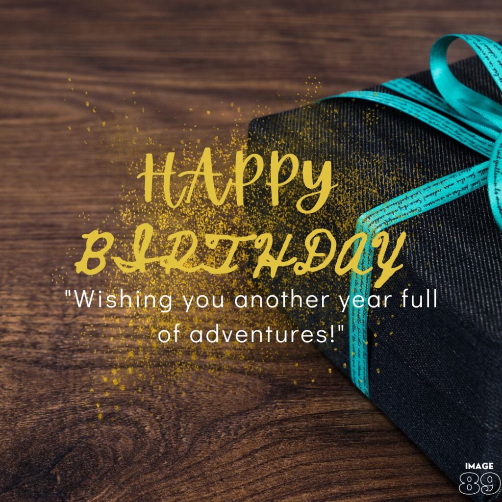 WOODEN background a gift on table in dark blue rapper and decorated with blue ribbon and happy birthday wishes